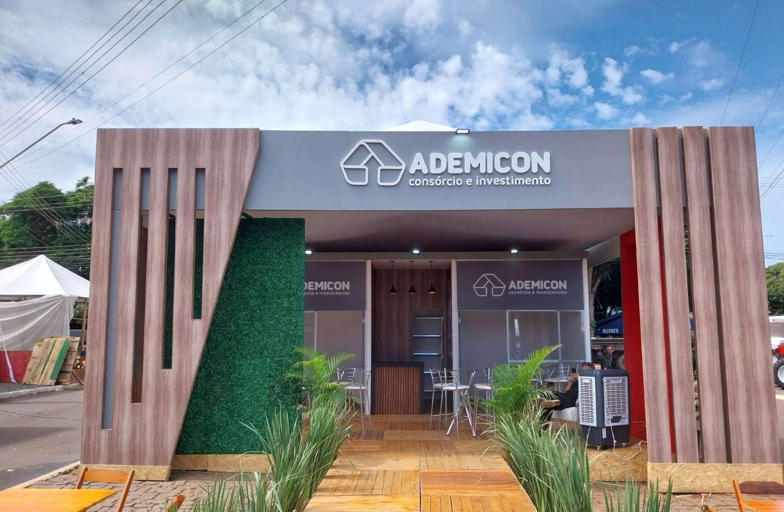 Estande premium da Ademicon com pórtico amadeirado, jardim vertical e iluminação embutida