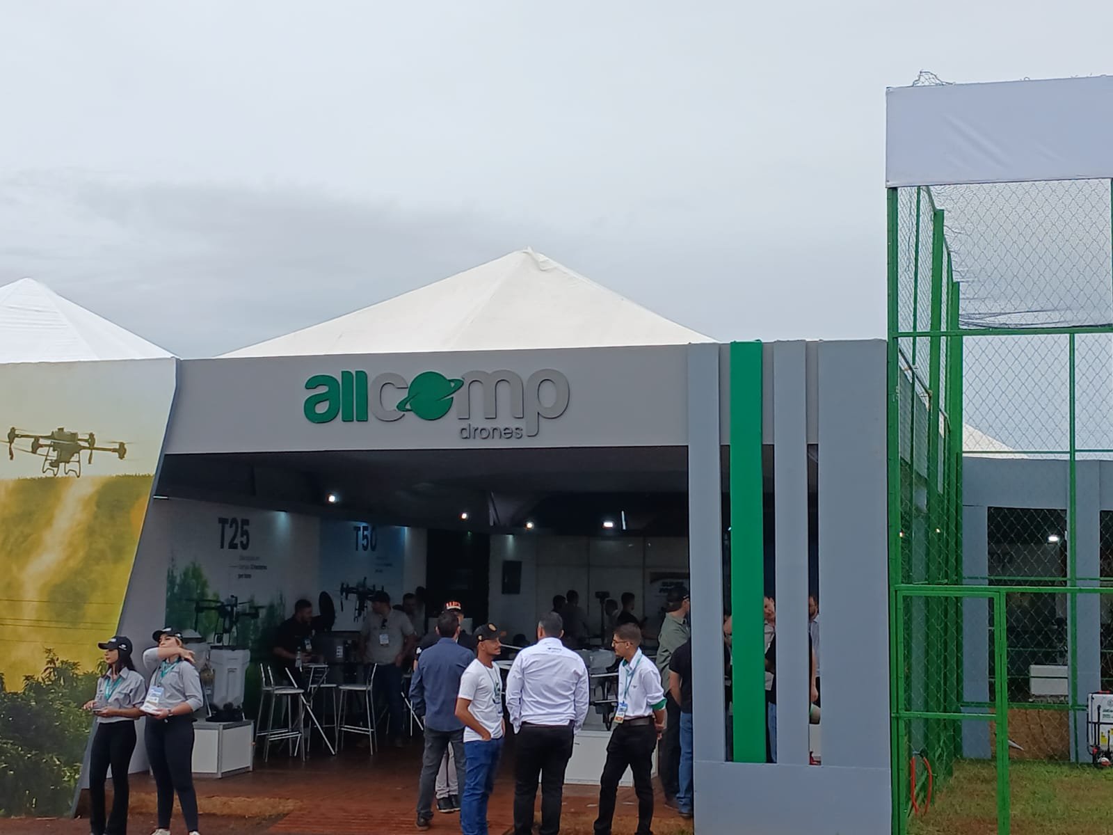 Estande Allcomp durante feira com circulação de público e recepção
